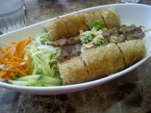 Grilled meat and spring rolls over vermicelli